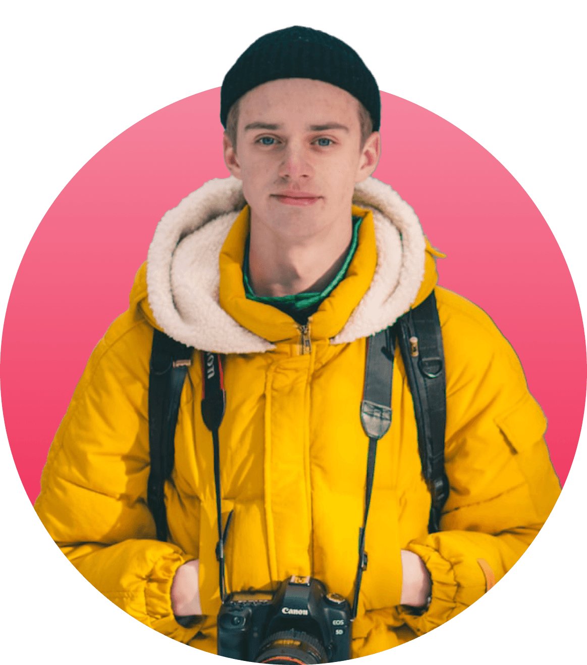 Boy on yellow jacket with a canon camera around his neck, smiling to the camera with hands in his pocket