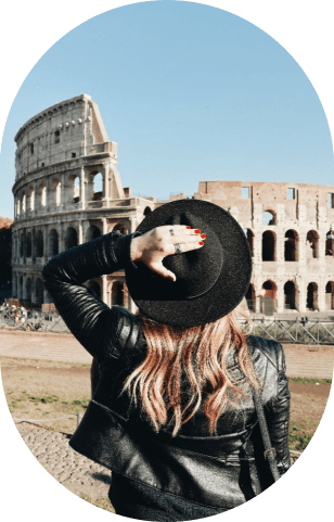 Woman holding her hat looking at the colosseum in Rome